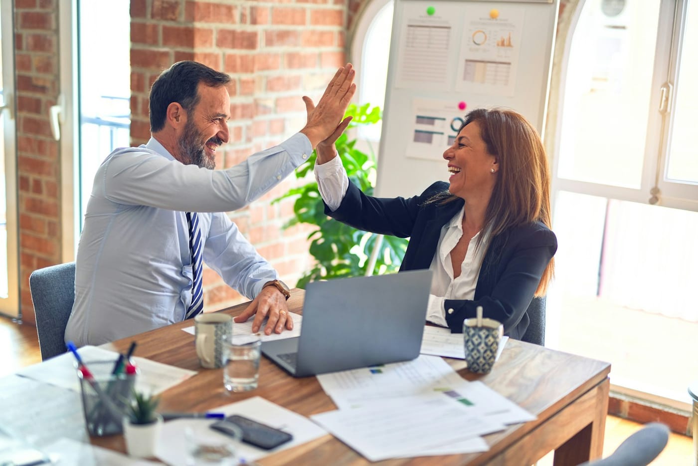 Queensland mortgage broker in professional consultation with self-employed client at modern Brisbane office
